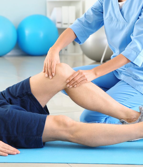 Physiotherapist working with male patient in rehabilitation center